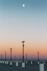 Silhouette street lights against clear sky at sunset