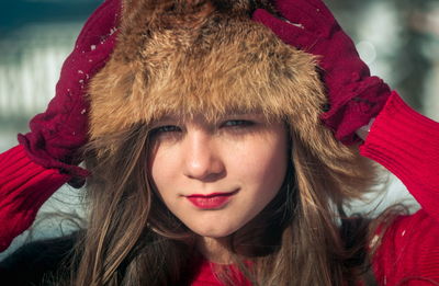 Portrait of smiling girl wearing fur hat while standing outdoors