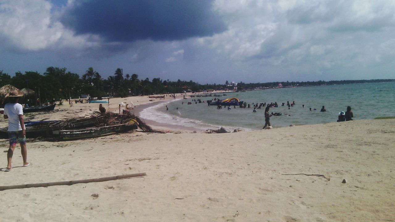 beach, sky, sea, water, cloud - sky, shore, sand, cloudy, cloud, scenics, nature, tranquility, incidental people, tranquil scene, beauty in nature, horizon over water, coastline, day, outdoors, vacations