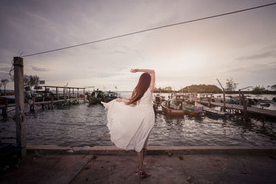 Rear view of woman on boat against sky during sunset