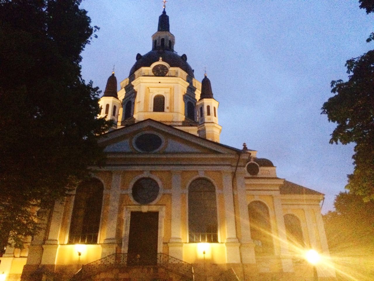 architecture, religion, building exterior, low angle view, place of worship, church, built structure, spirituality, tree, cathedral, illuminated, sky, night, cross, history, outdoors, dome, clear sky