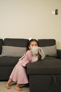 Boy sitting on sofa at home