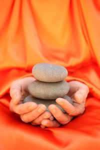 Cropped hands holding stacked pebbles