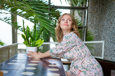 Portrait charming woman is calling, sitting alone in cafe in her free time