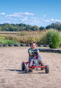 Over joyed child has fun driving a pedal car around a track