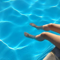 Low section of person swimming in pool