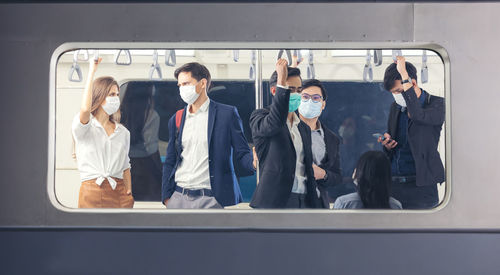 People on the train wear anti-virus masks and travel during rush hours. passengers inside the sky 