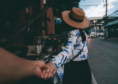 Midsection of man holding woman standing by umbrella