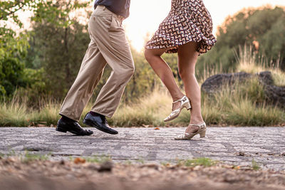 Low section of women walking on footpath