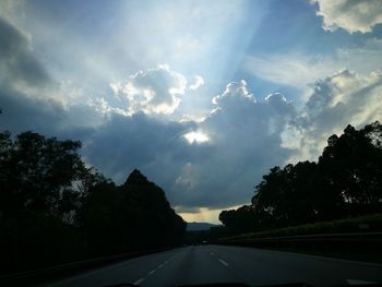 Road amidst trees against sky