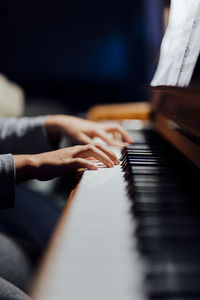 Piano player in beutiful light you can only see players hands that is practicing piano lesson.