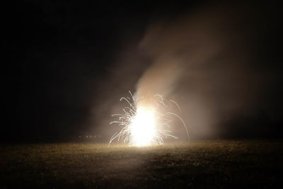 Close-up of illuminated field against sky at night