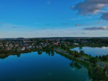 High angle view of townscape by river against blue sky