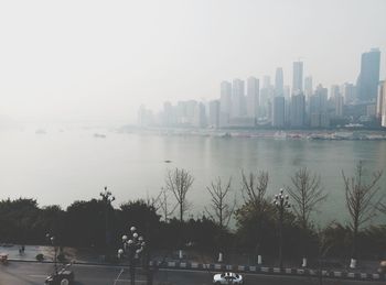 City at waterfront against clear sky