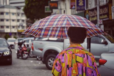 Rear view of people with umbrella on street