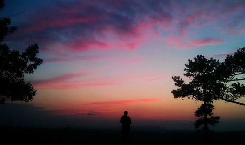 Silhouette man on beach against sky during sunset