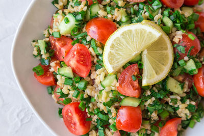 Tabbouleh salad on a dish on light background. lebanese cuisine. top view.