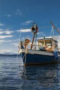 Fishing boat moored in sea against sky