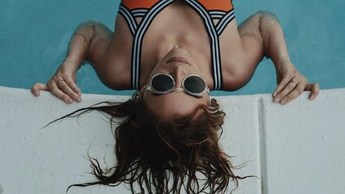 High angle view of young woman wearing sunglasses in swimming pool