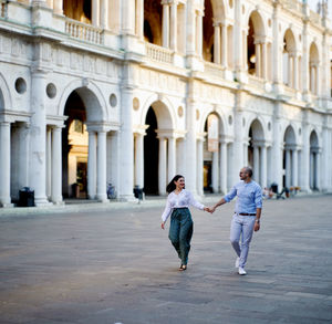 Front view of a man and a woman couple walking on street in city