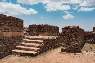 Stack of old ruin building against cloudy sky