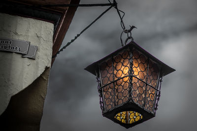 Low angle view of illuminated lanterns hanging by building