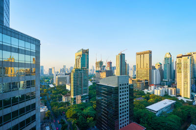 Buildings in city against clear blue sky