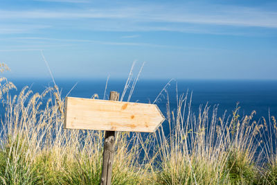 Wooden posts on beach against sky