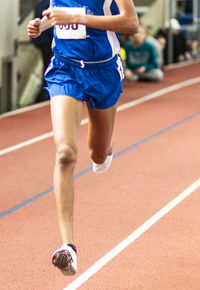 Low section of athlete running on sports track