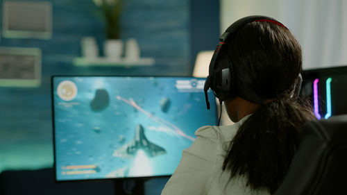 Rear view of woman playing video game