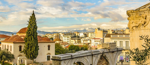 Buildings in city against cloudy sky