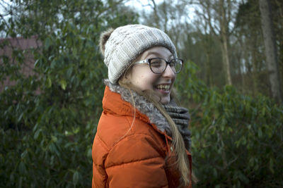 Portrait of smiling man standing by plants during winter