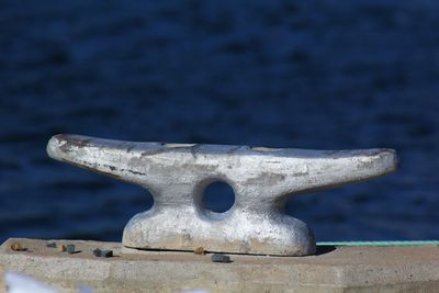 Close-up of metallic bollard at harbor