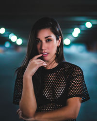 Portrait of beautiful young woman standing at night