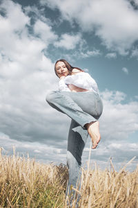 Woman standing on field against sky