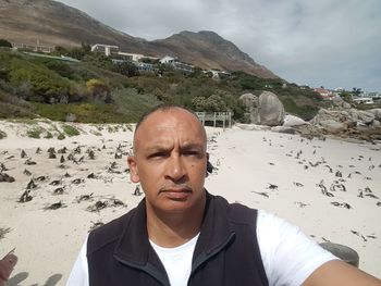 Portrait of man at beach against sky