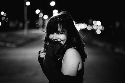 Full length portrait of young woman at night