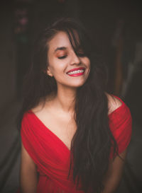 Smiling young woman wearing red dress and lipstick