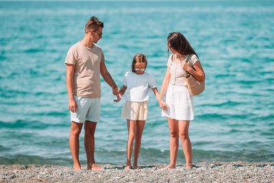 Rear view of people standing at beach