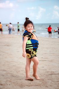 Full length portrait of girl standing at beach