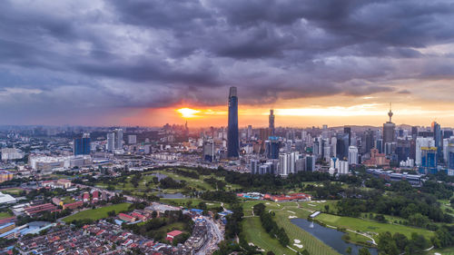 Aerial view of buildings against cloudy sky during sunset