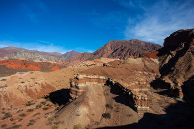 Panoramic view of rocky mountains against blue sky