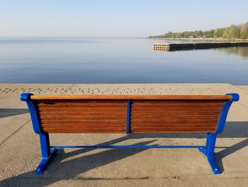  bench by sea against blue sky