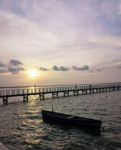 Pier over sea against sky during sunset