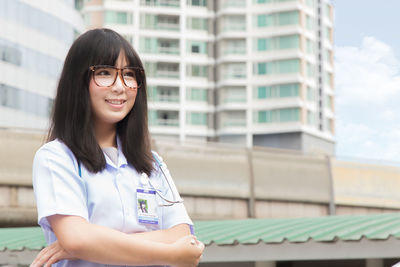 Young female doctor standing in city