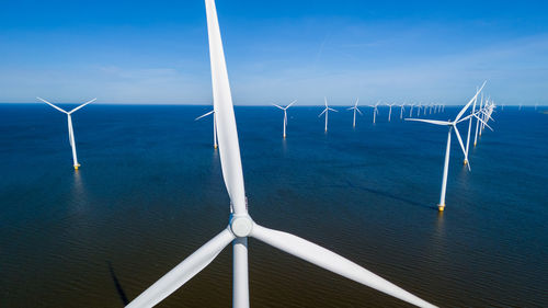 Low angle view of windmill against blue sky