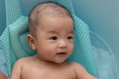 Cute baby girl lying in container