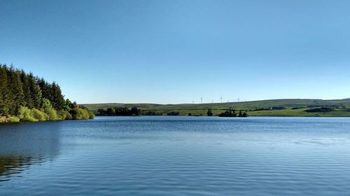 Scenic view of lake against clear blue sky