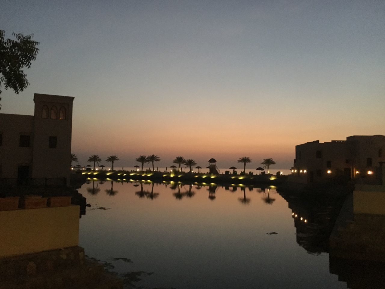 REFLECTION OF BUILDINGS IN LAKE AGAINST CLEAR SKY