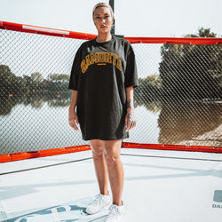 Portrait of young woman standing against fence